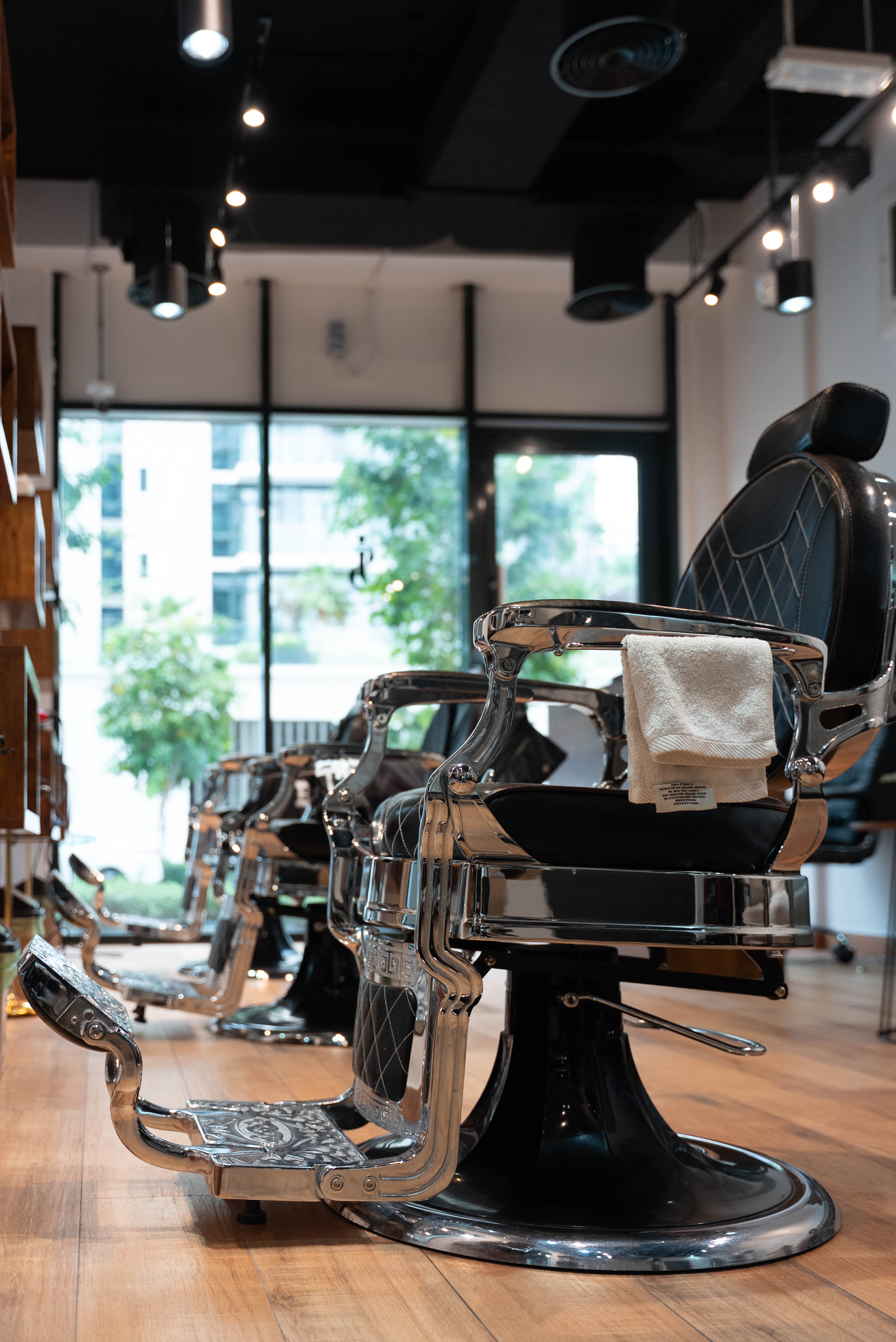 Row of polished chrome barber chairs by the window